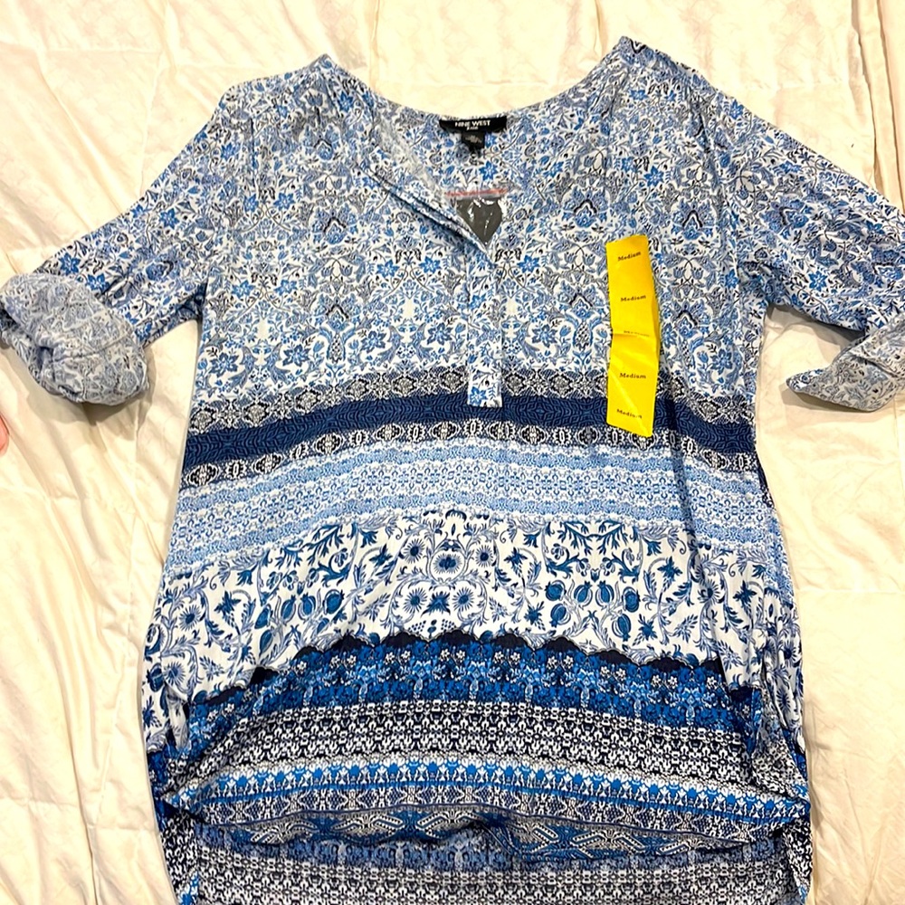 Blue and white floral print top with v neck and 3/4 button.  Cuffed sleeves